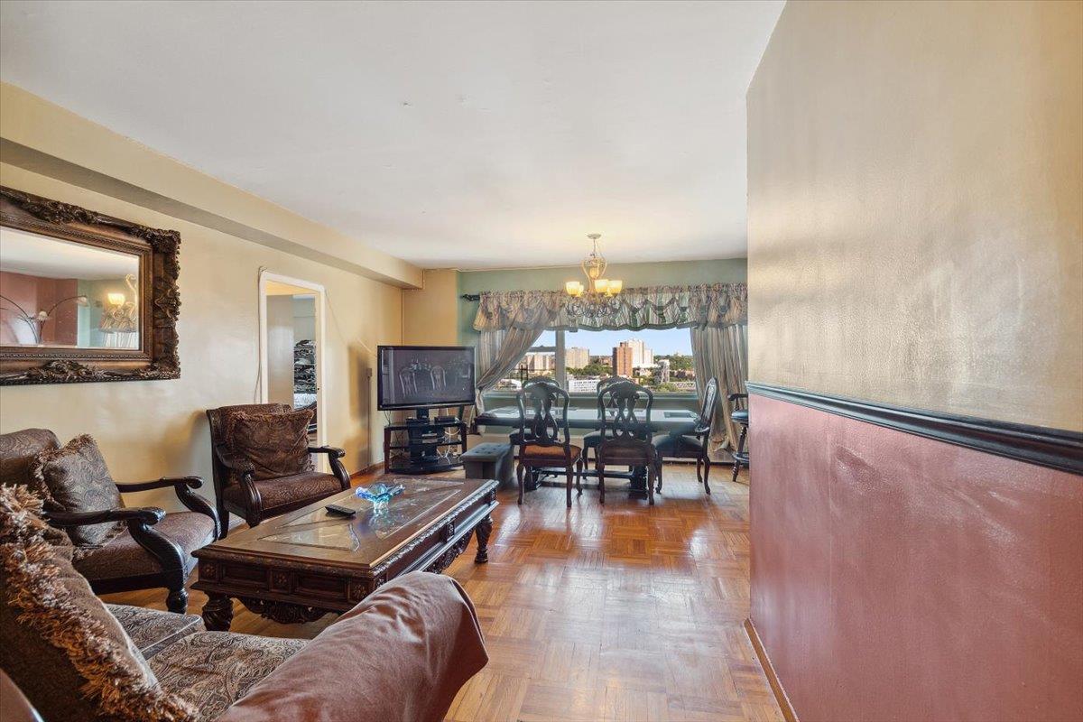 3 Fordham Hill Ovl, Unit 10B Bronx, NY 10468 - Photo 4 of 33 Living room with a chandelier and baseboards