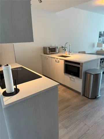 a kitchen with a stove and wooden floor