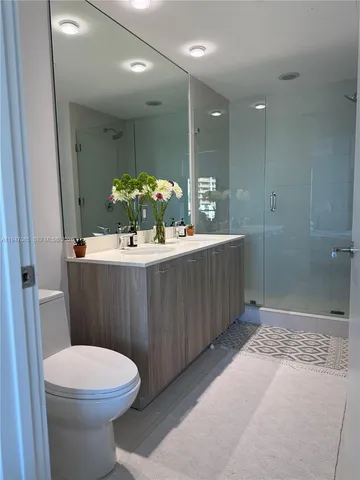 a bathroom with a sink mirror vanity and toilet