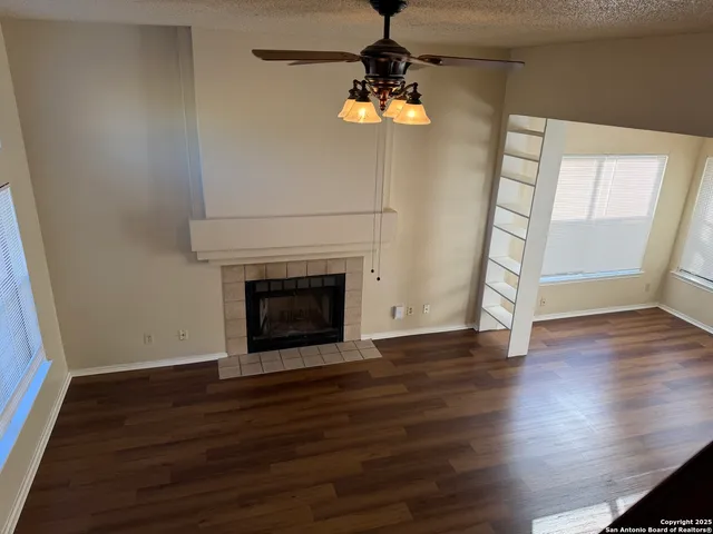 a view of empty room with wooden floor and fireplace