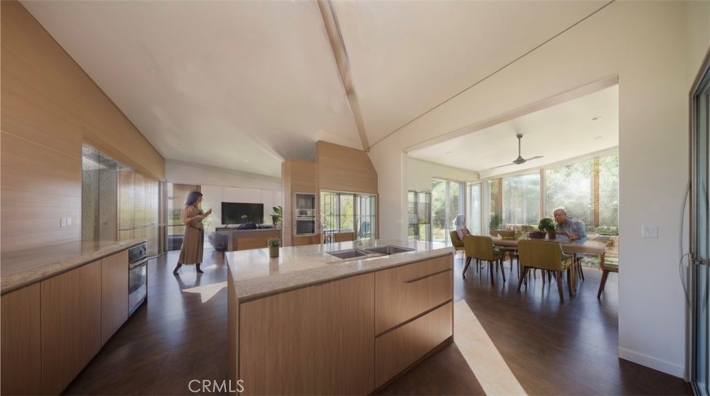 82935 Maya Rada Road Twentynine Palms, CA 92277 - Photo 3 of 30 a dining hall with stainless steel appliances granite countertop a stove a refrigerator a dining table and chairs with wooden floor