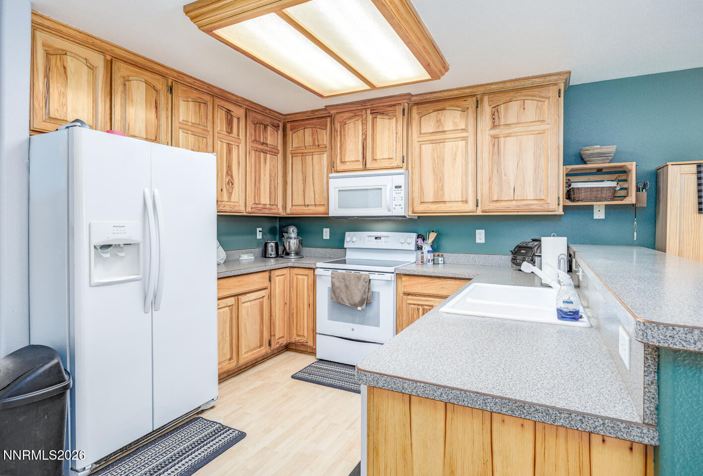 374 Calaway Court Fallon, NV 89406 - Photo 6 of 18 a kitchen with granite countertop a refrigerator a sink a stove and white cabinets