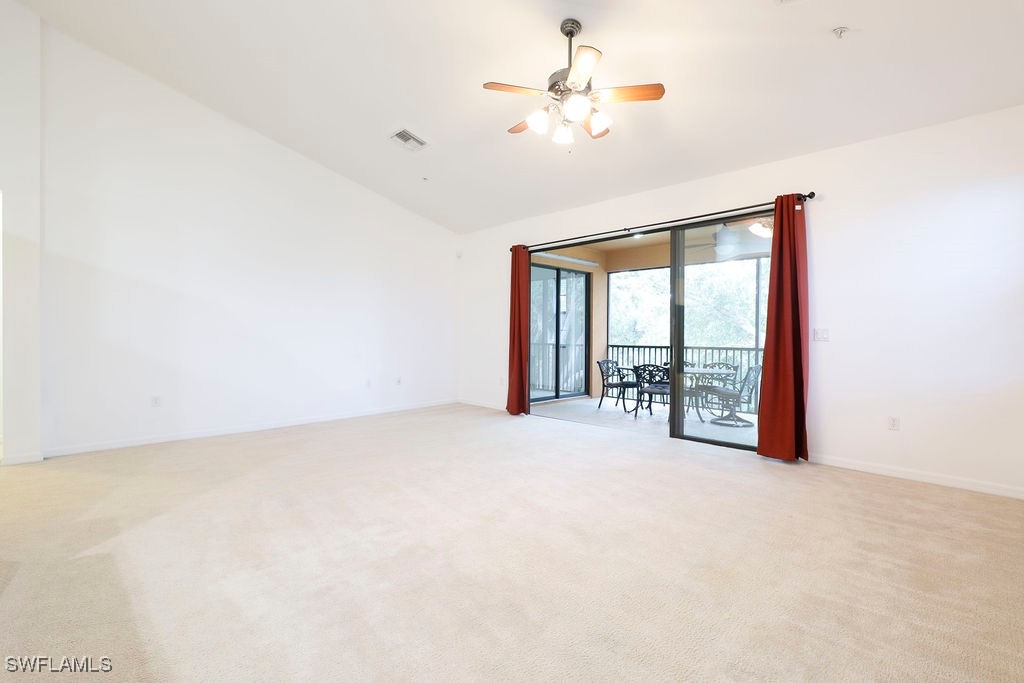 3799 Costa Maya Way, Unit 202 Estero, FL 33928 - Photo 12 of 42 an empty room with chandelier fan and windows