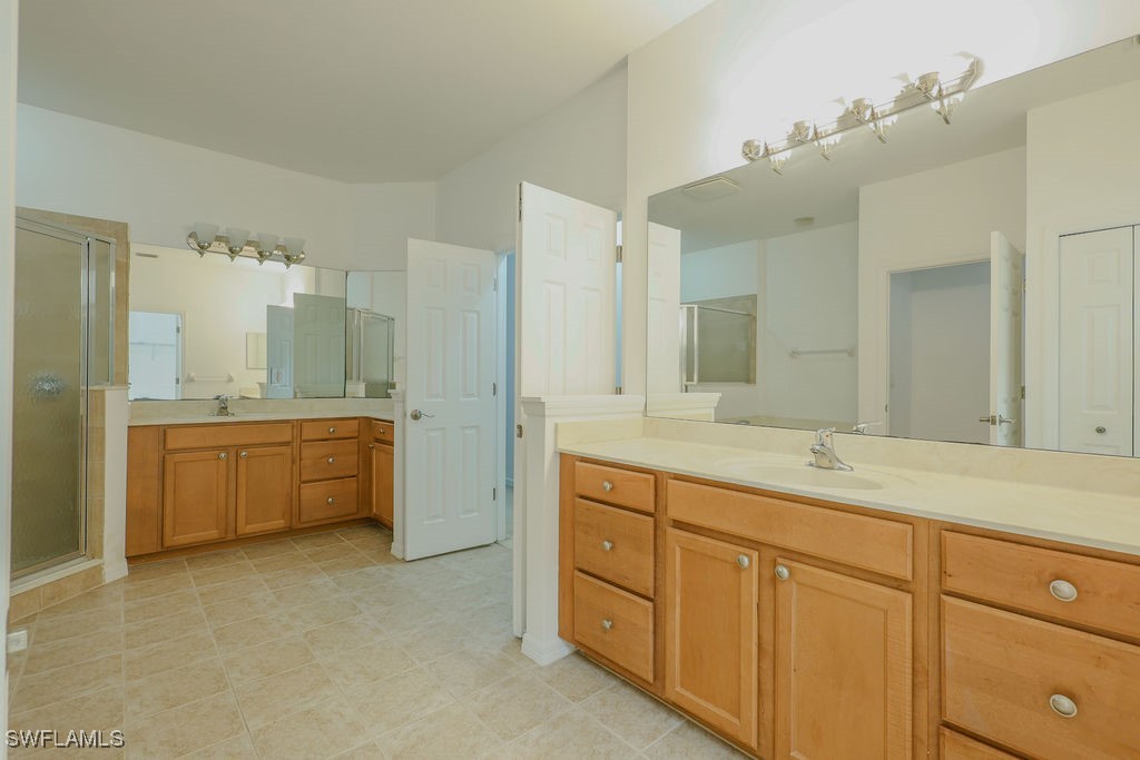 3799 Costa Maya Way, Unit 202 Estero, FL 33928 - Photo 13 of 42 a bathroom with a granite countertop double vanity sink mirror and bathtub