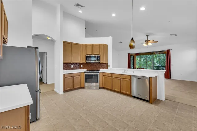 a kitchen with stainless steel appliances kitchen island granite countertop a stove a sink and a refrigerator