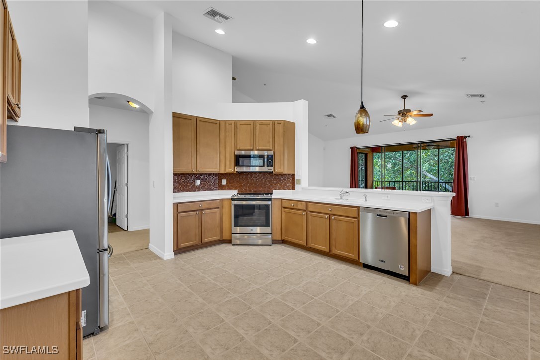 3799 Costa Maya Way, Unit 202 Estero, FL 33928 - Photo 2 of 42 a kitchen with stainless steel appliances kitchen island granite countertop a stove a sink and a refrigerator
