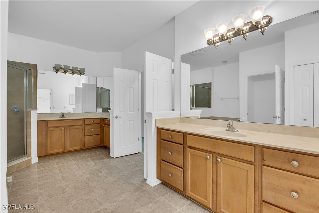 3799 Costa Maya Way, Unit 202 Estero, FL 33928 - Photo 22 of 42 a bathroom with a double vanity sink a mirror a bathtub and shower