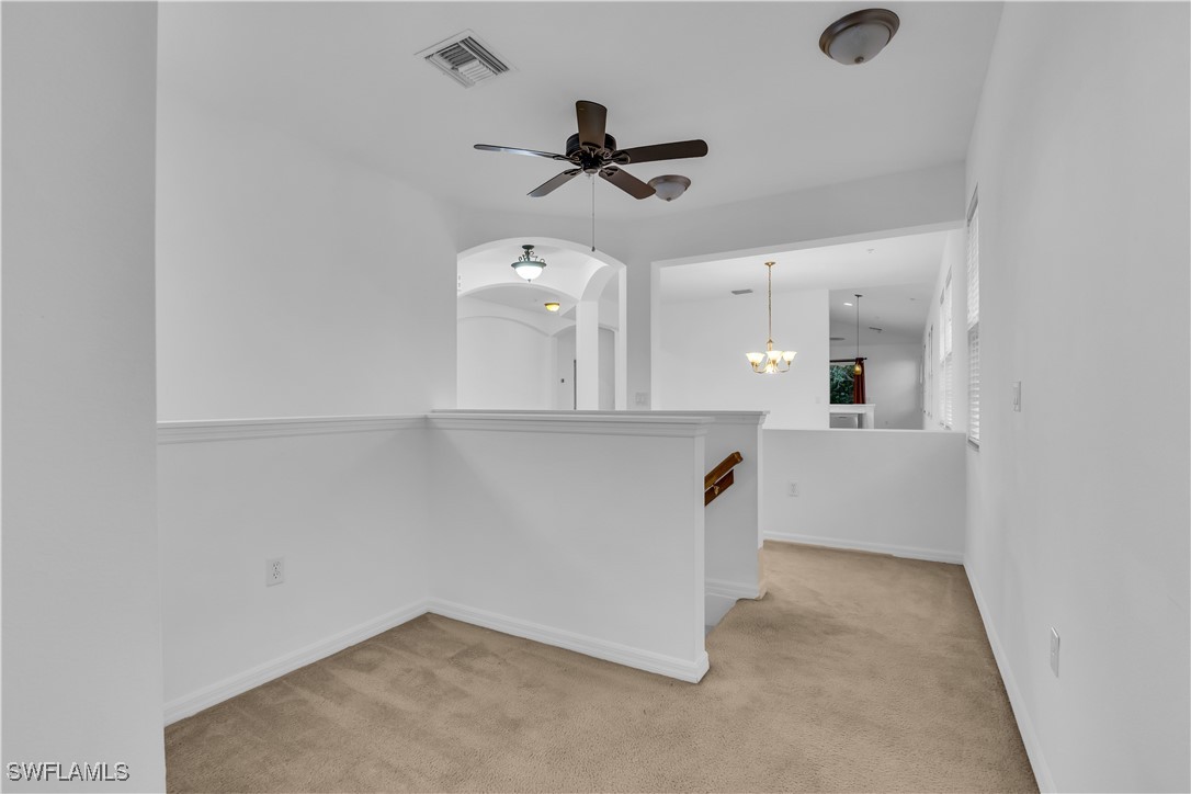 3799 Costa Maya Way, Unit 202 Estero, FL 33928 - Photo 32 of 42 an empty room with a ceiling fan and kitchen view