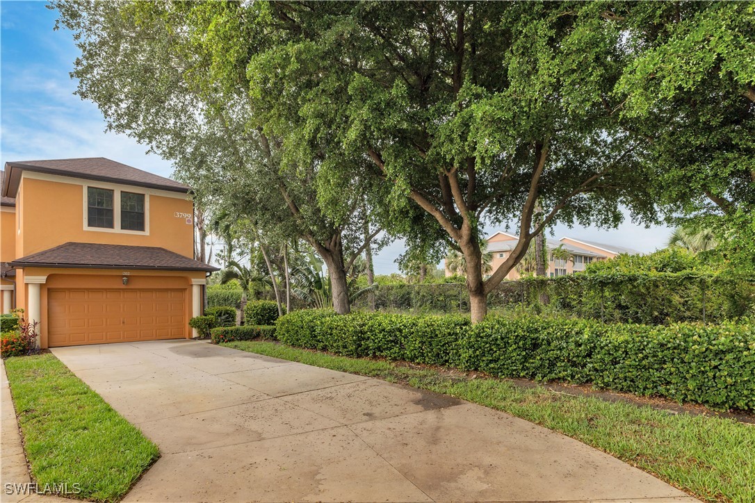 3799 Costa Maya Way, Unit 202 Estero, FL 33928 - Photo 37 of 42 a front view of a house with a garden