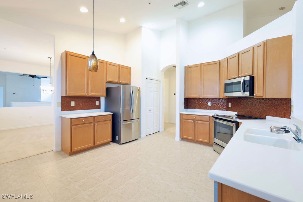 3799 Costa Maya Way, Unit 202 Estero, FL 33928 - Photo 5 of 42 a kitchen with stainless steel appliances a refrigerator sink and microwave