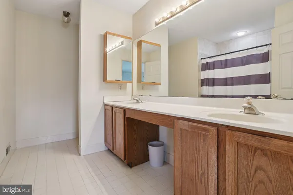 a bathroom with a double vanity sink and a mirror