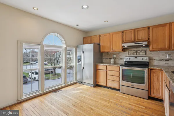 a kitchen with stainless steel appliances a stove top oven and a refrigerator