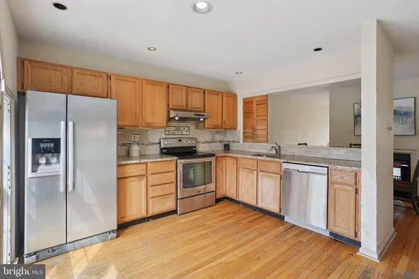 a kitchen with stainless steel appliances granite countertop a refrigerator sink and cabinets