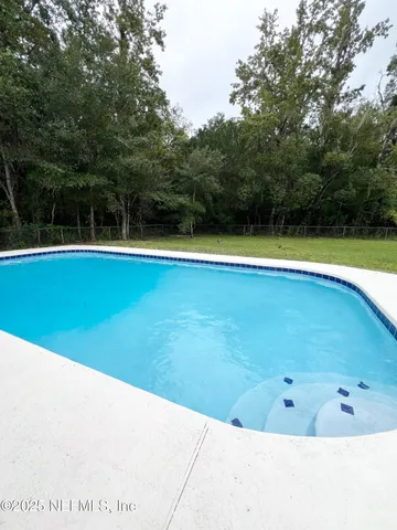 a view of a swimming pool and trees in the background