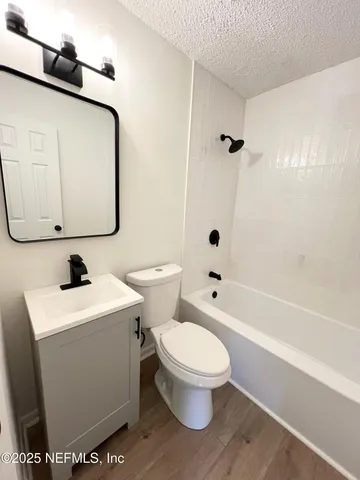 a white toilet sitting next to a bathroom sink and a shower