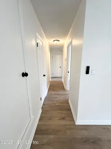 a view of a hallway with wooden floor and staircase
