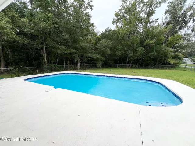 a view of a swimming pool and trees in the background