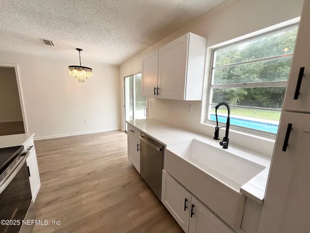 a kitchen with granite countertop a sink and a stove top oven