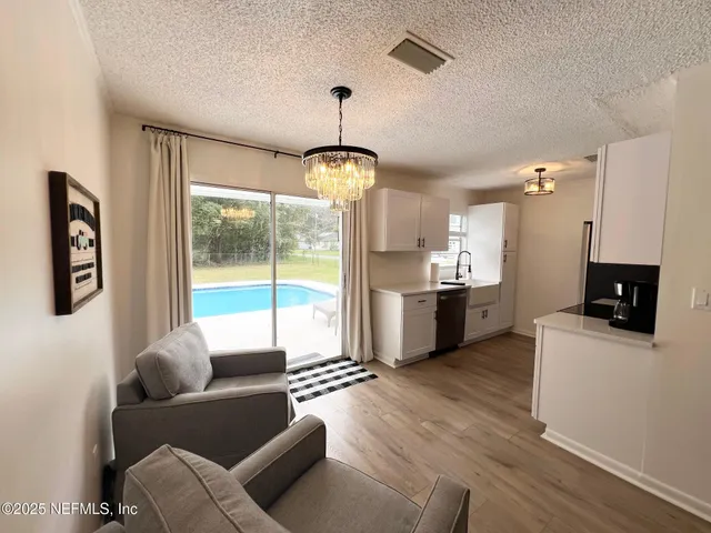 a living room with stainless steel appliances furniture and a large window