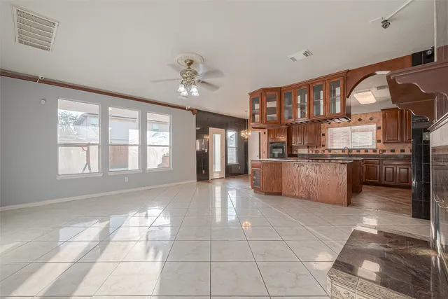 a large kitchen with stainless steel appliances granite countertop a stove a sink dishwasher and a view of living room