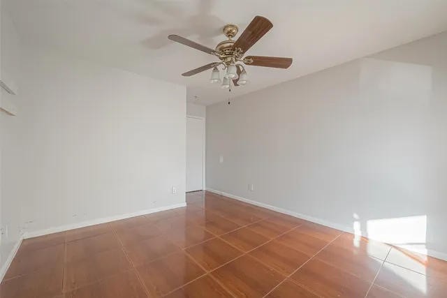 an empty room with a ceiling fan and a window
