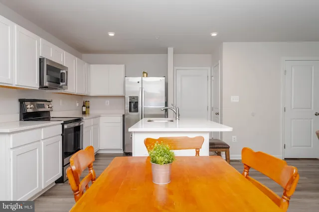 a kitchen with a refrigerator and a stove top oven
