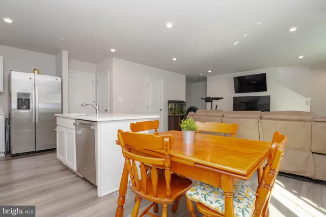 a kitchen with stainless steel appliances kitchen island granite countertop a refrigerator and a stove top oven with wooden floor