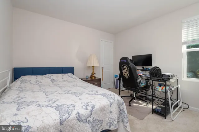 a bedroom with a bed and a computer on a desk