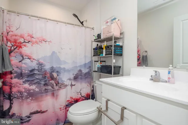 a bathroom with a sink vanity mirror and toilet