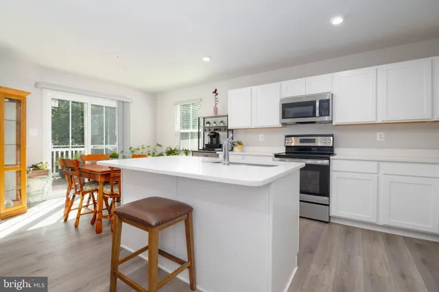 a kitchen with a sink cabinets and dining table chair