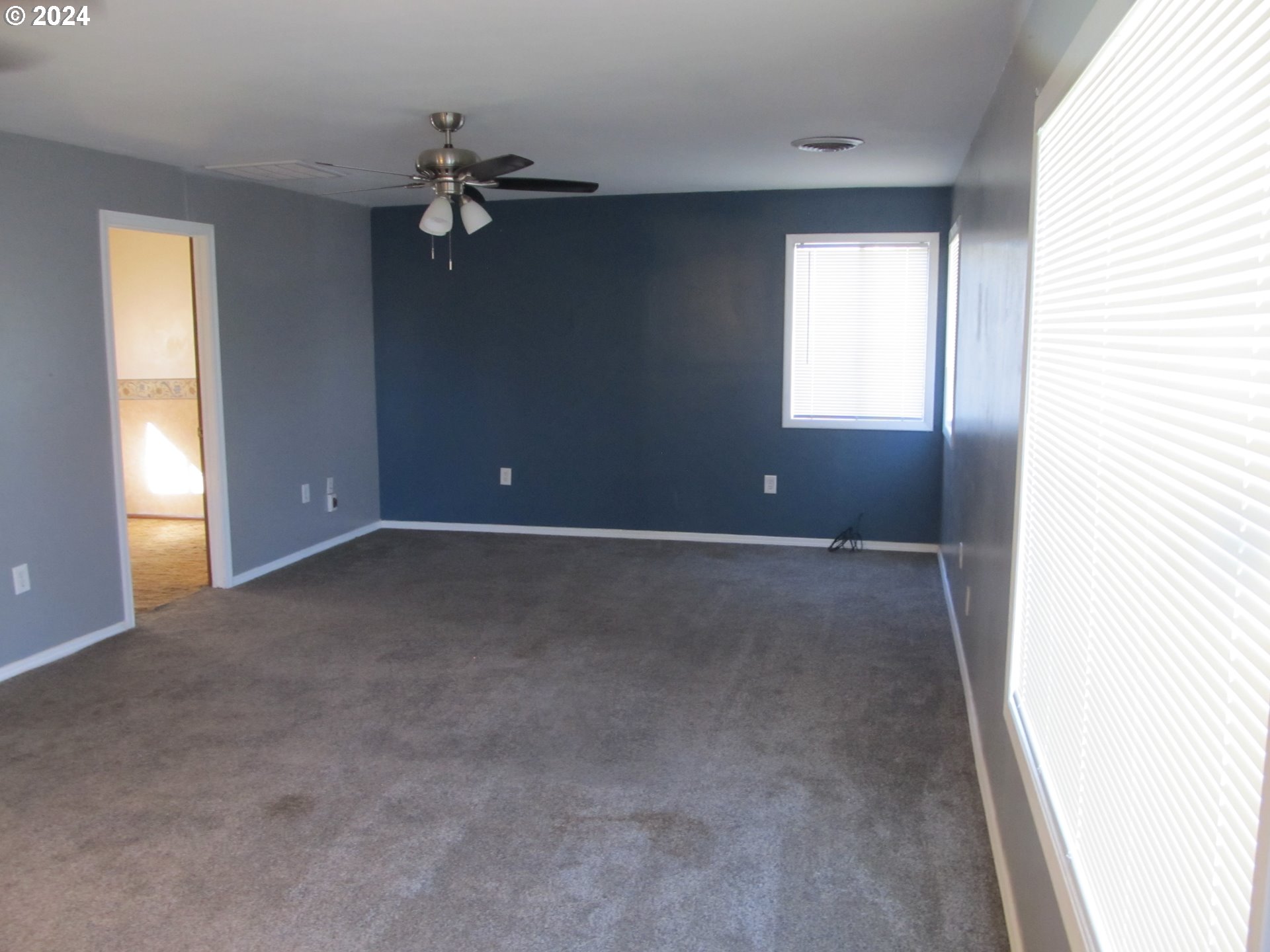 1890 East Hooker Road Hermiston, OR 97838 - Photo 6 of 32 an empty room with a chandelier fan and windows