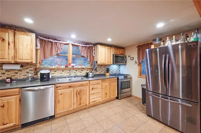 a kitchen with stainless steel appliances granite countertop a refrigerator and a sink