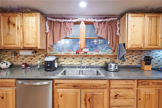 a kitchen with stainless steel appliances kitchen island granite countertop a table chairs and a refrigerator
