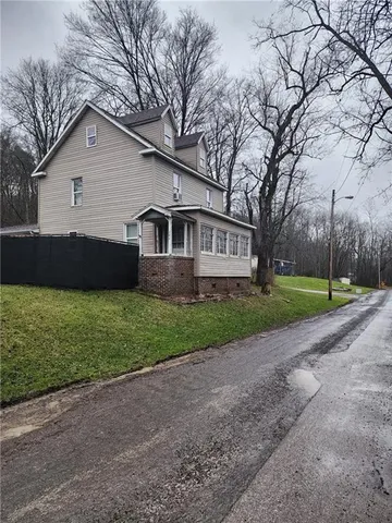 a view of a house with backyard porch and sitting area