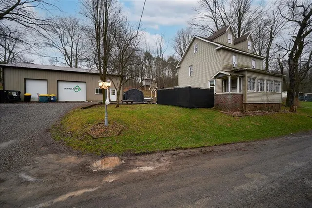 a view of a house with a yard chairs and a fire pit