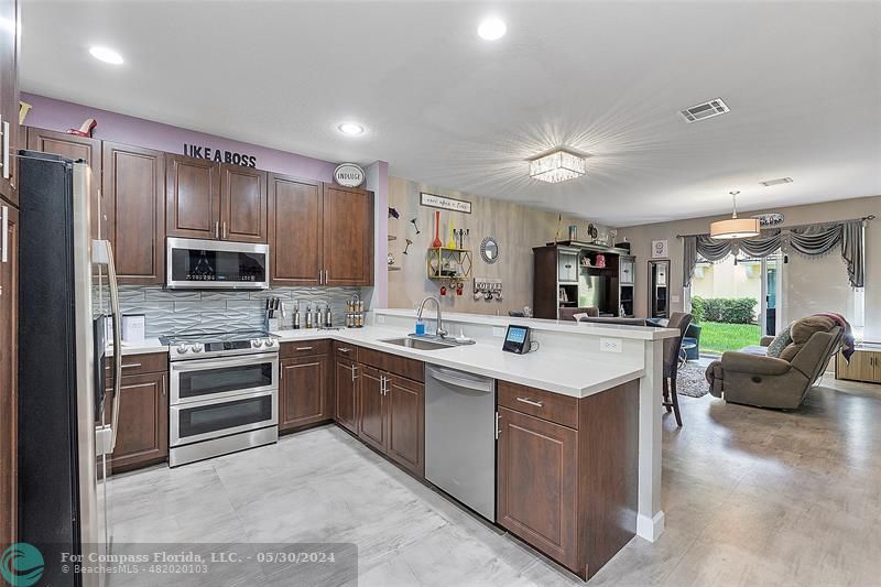 7774 Paddock Place, Unit 7774 Davie, FL 33328 - Photo 6 of 28 a kitchen with stainless steel appliances granite countertop a sink stove and refrigerator