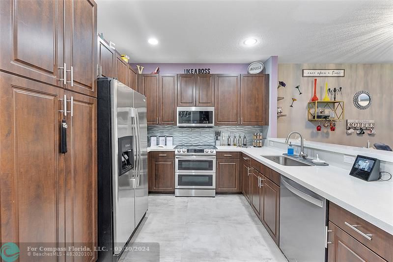 7774 Paddock Place, Unit 7774 Davie, FL 33328 - Photo 7 of 28 a kitchen with stainless steel appliances granite countertop a refrigerator and a sink
