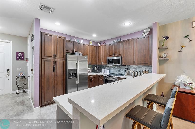 7774 Paddock Place, Unit 7774 Davie, FL 33328 - Photo 8 of 28 a kitchen with refrigerator cabinets and large counter space