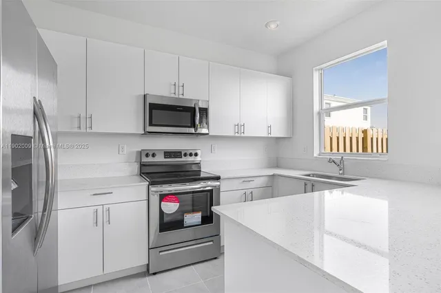 a kitchen with stainless steel appliances granite countertop a sink and a microwave