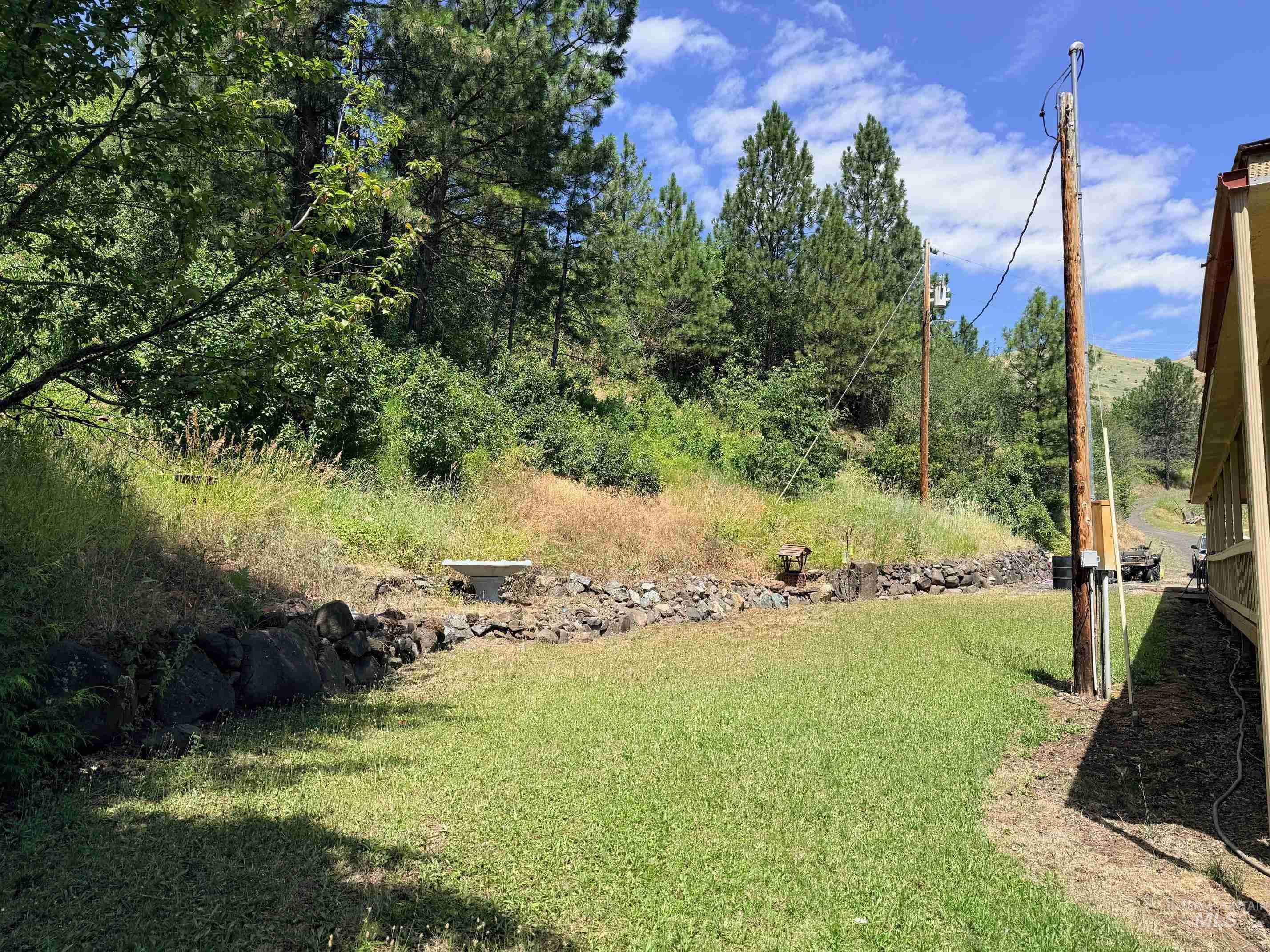 35322 River Road Lenore, ID 83541 - Photo 31 of 42 Expansive grassy area with a natural stone retaining wall and mature trees