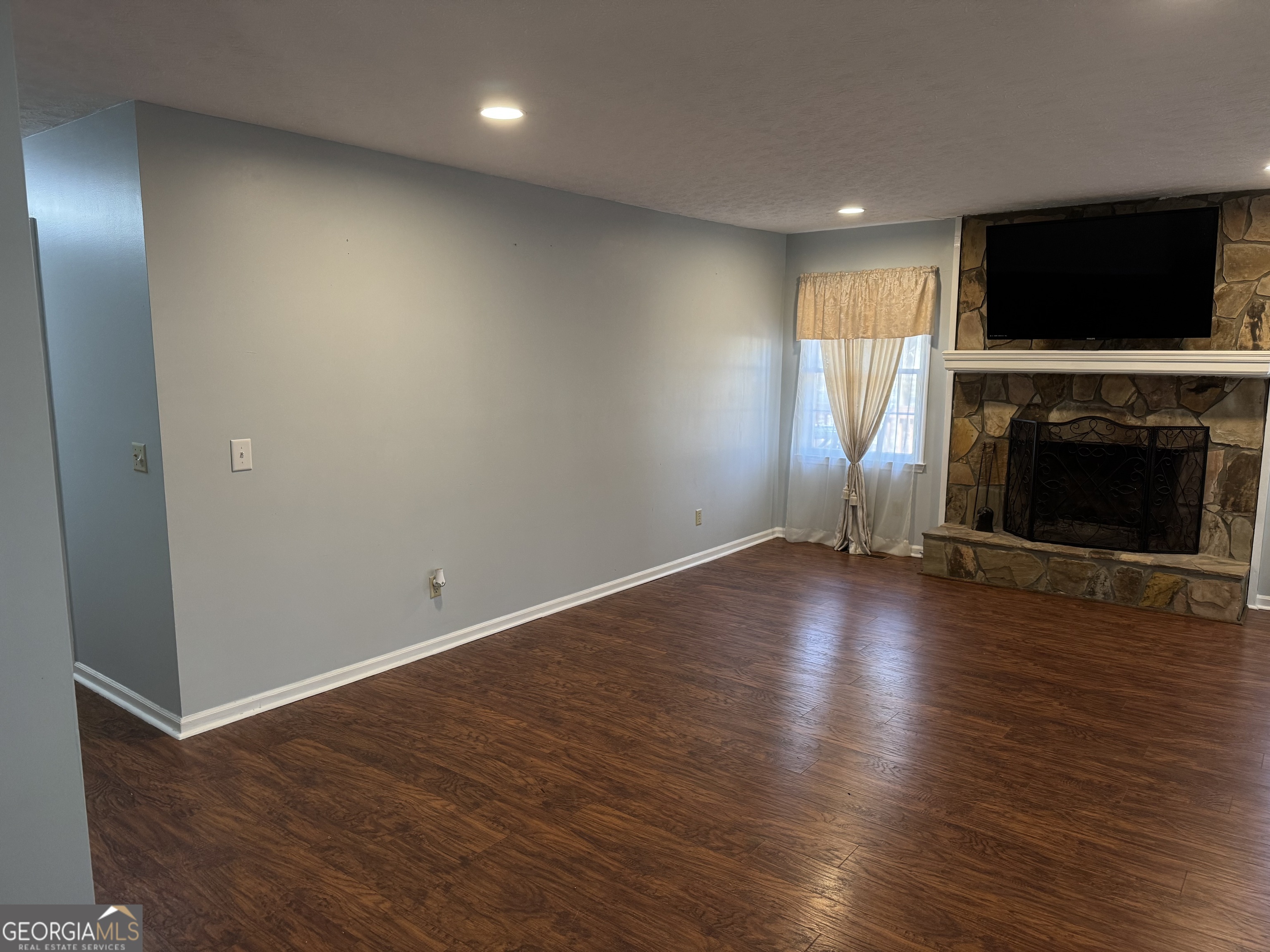 4055 Golfview Drive Villa Rica, GA 30180 - Photo 5 of 28 an empty room with wooden floor fireplace and windows