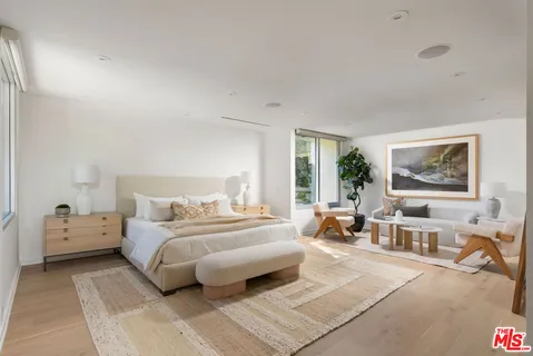 a bedroom with furniture and a large window