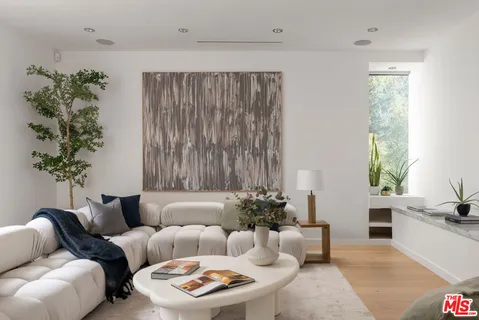 a living room with furniture and a potted plant
