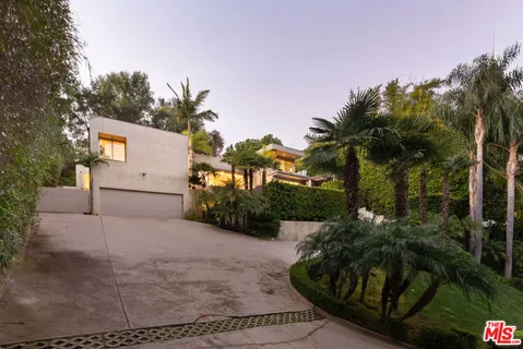a view of a house with a yard and potted plants