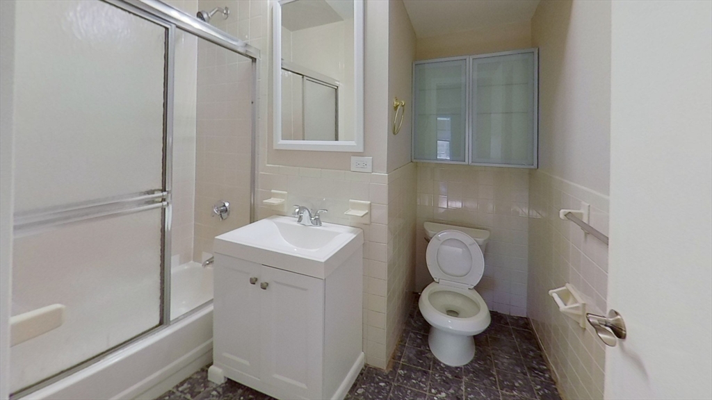119 George Street, Unit 3 Boston, MA 02119 - Photo 7 of 8 a bathroom with a toilet sink and mirror