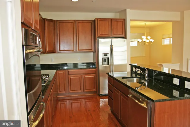 a kitchen with granite countertop a sink and a refrigerator