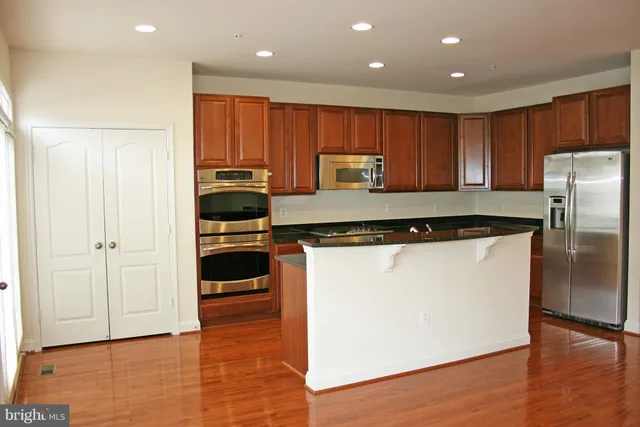 a kitchen with a refrigerator and a stove top oven