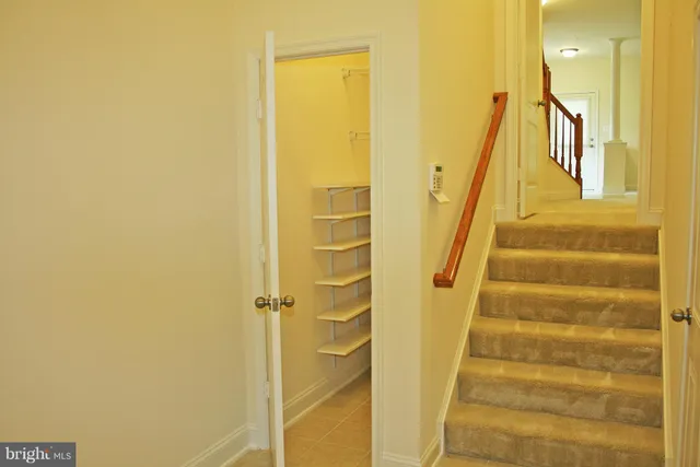 a view of a hallway with wooden floor and a shower