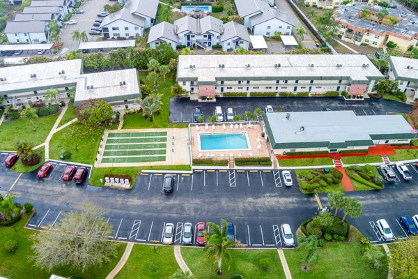 an aerial view of a swimming pool with a yard and plants