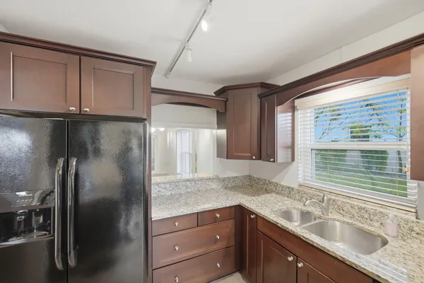a kitchen with stainless steel appliances granite countertop a sink and refrigerator